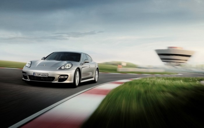 Silver Porsche Panamera driving on a race track