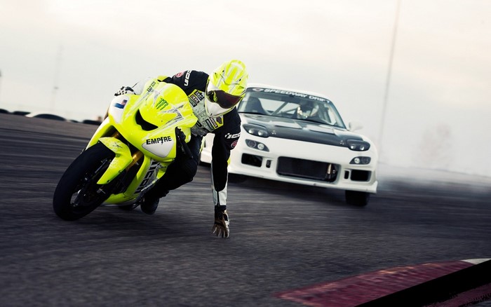 Motorcycle racer and drift car on a race track