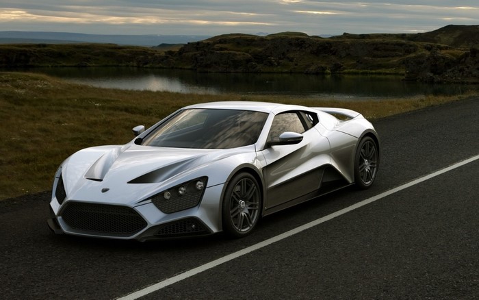 Zenvo ST1 supercar on a road with a lake and hills