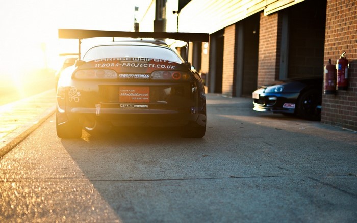 Toyota Supra with large rear spoiler at sunset