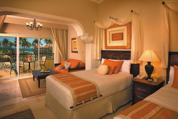 Hotel room with balcony overlooking palm trees and ocean