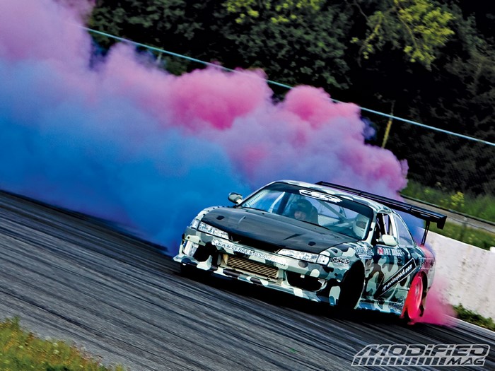 Drifting car with pink and blue smoke