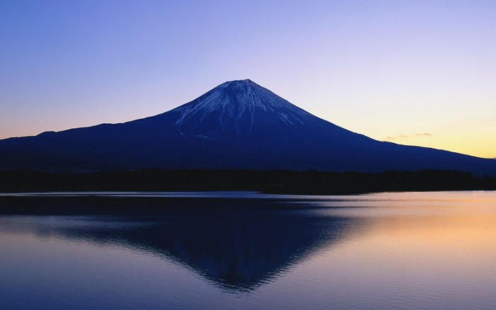 Mount Fuji reflected in a lake at dawn