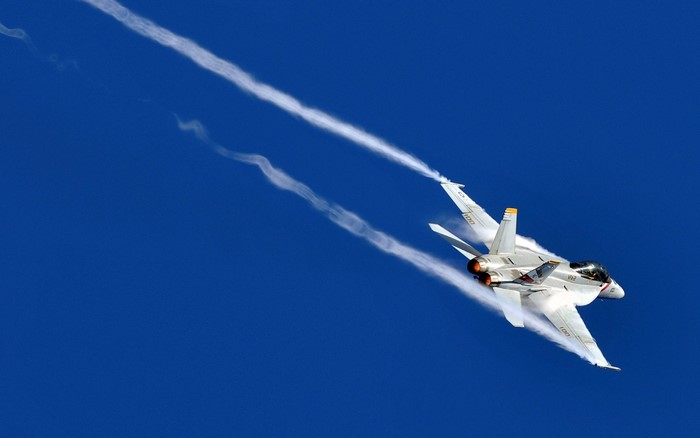 Fighter jet performing aerobatics with contrails