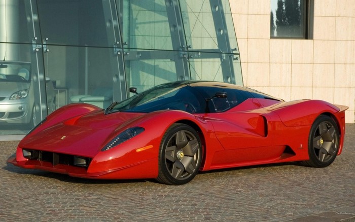Red Ferrari P4/5 by Pininfarina parked outside a modern building