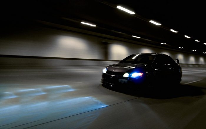 Dark Mitsubishi Sports Car Driving Through Tunnel at Night