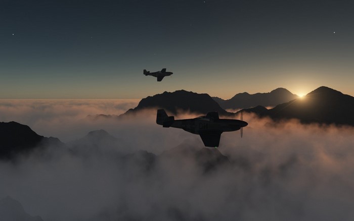 Two North American P-51 Mustangs fly over mountains at dawn