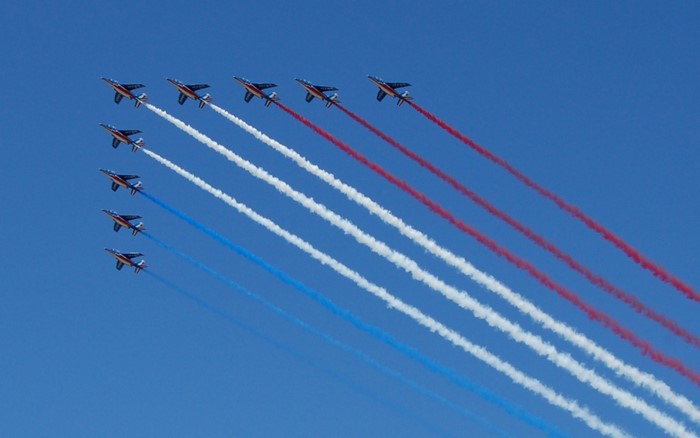 Patrouille de France jets flying in formation with colored smoke
