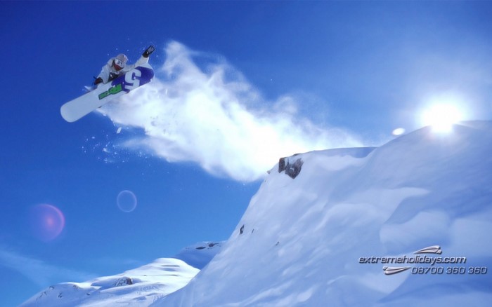 Snowboarder jumping off a snowy cliff