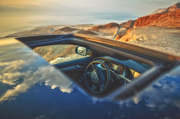 Audi car interior with sunroof open in desert landscape