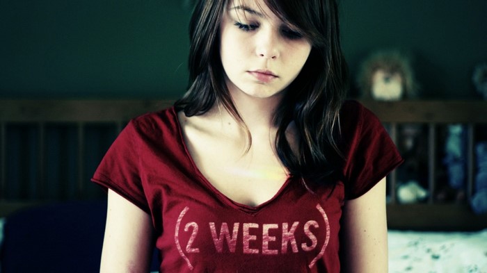 Young woman in red t-shirt with "2 WEEKS" text