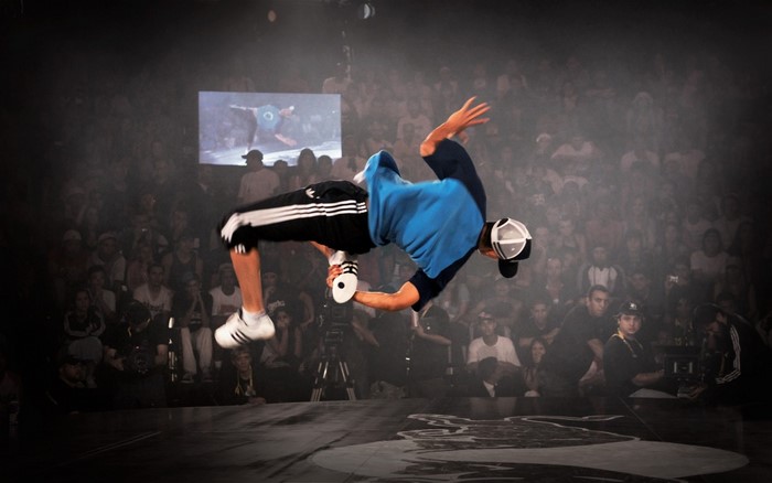 Breakdancer performing a flip in front of a crowd