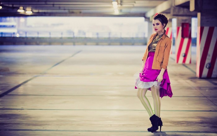 Woman in fashionable outfit posing in parking garage