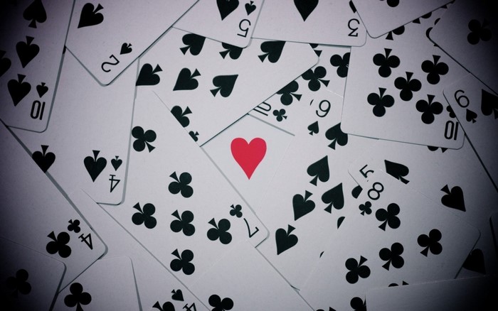 Scattered playing cards with suits and numbers