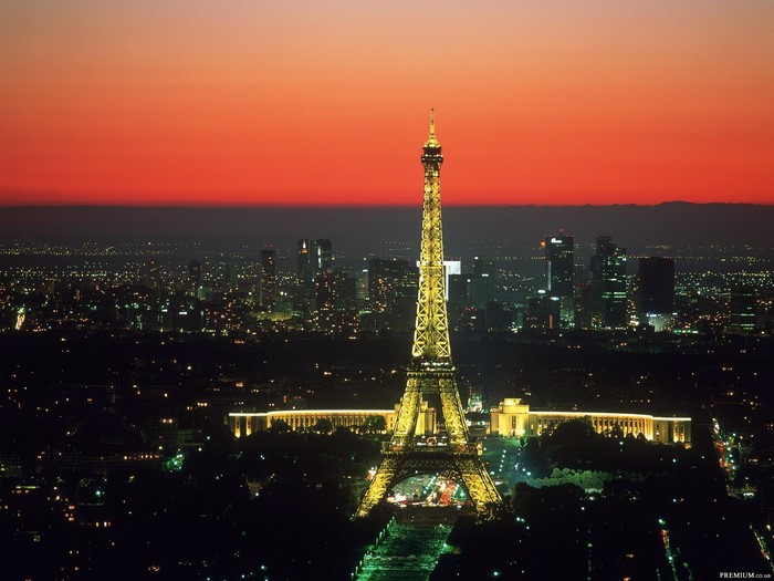 Eiffel Tower illuminated at dusk over Paris cityscape