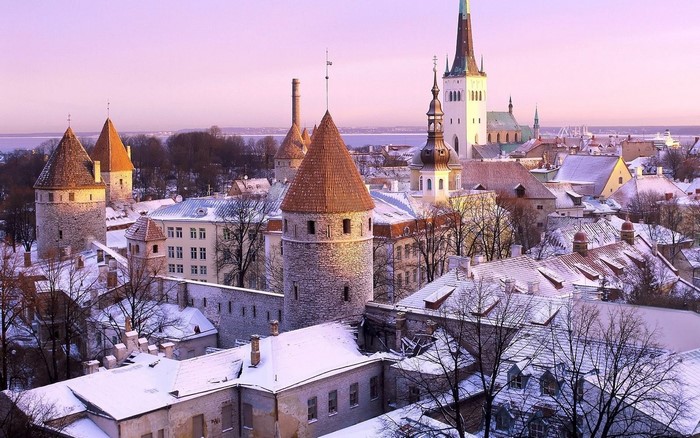 Tallinn cityscape with snow-covered roofs and towers at sunset