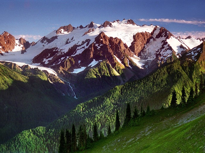 Snow-capped mountains with green forested valley