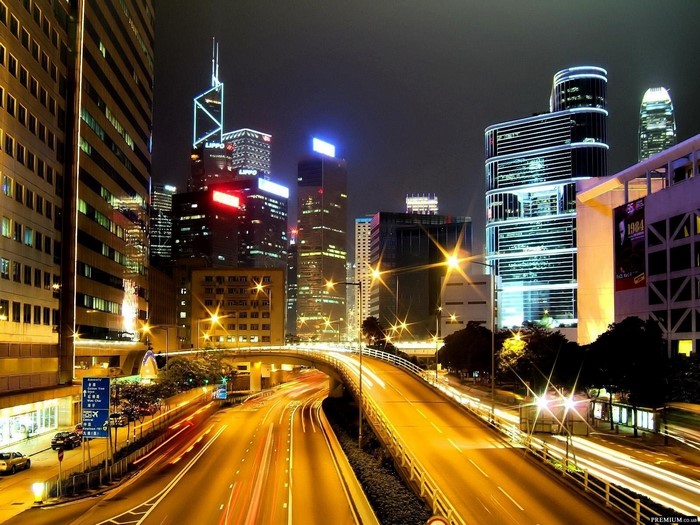 Hong Kong cityscape at night with traffic on overpass
