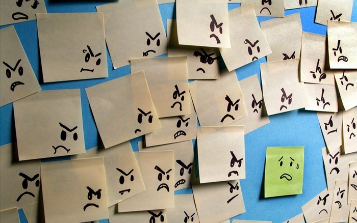 Angry faces drawn on sticky notes