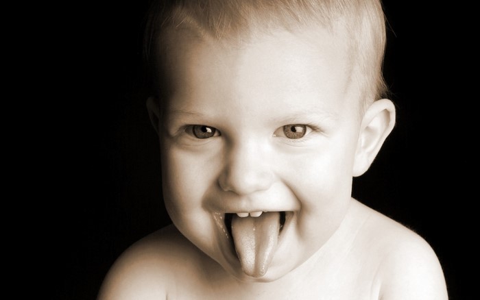 Toddler sticking tongue out in monochrome portrait
