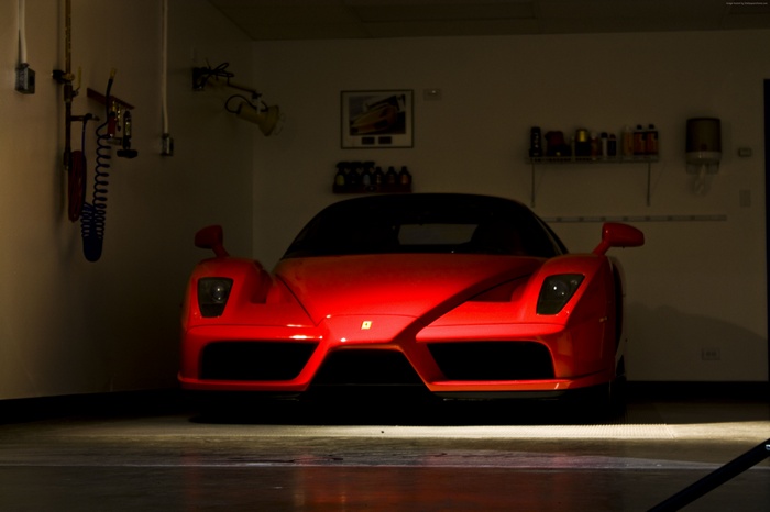 Red Enzo Ferrari supercar in a garage
