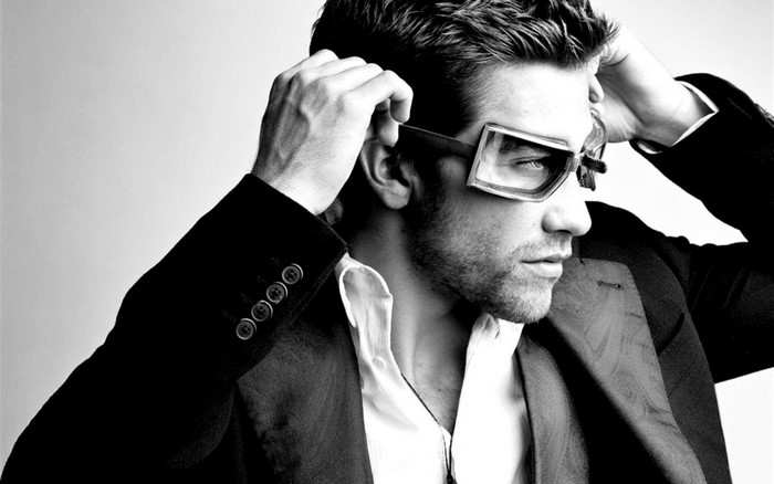 Man in suit and sunglasses adjusting hair