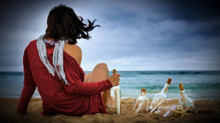 Woman with messages in bottles on a beach