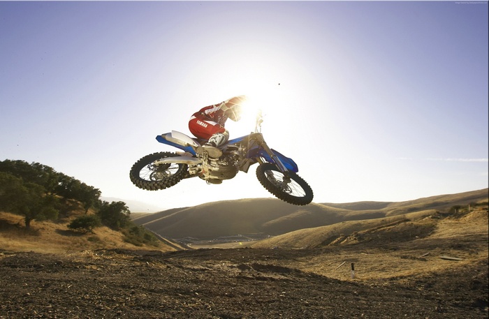 Motocross rider on Yamaha YZ250F jumping over a dirt track