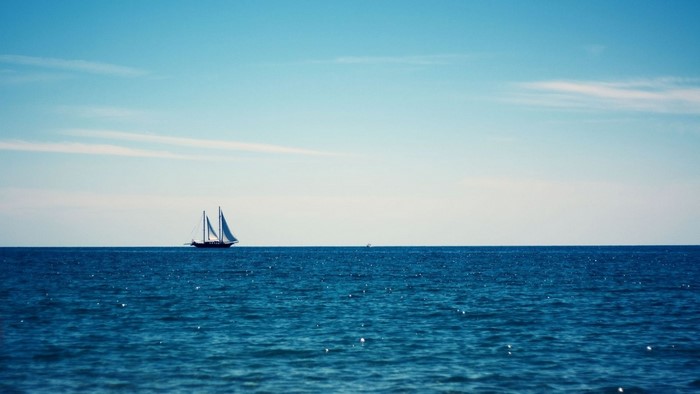 Sailboat on the blue ocean under a clear sky