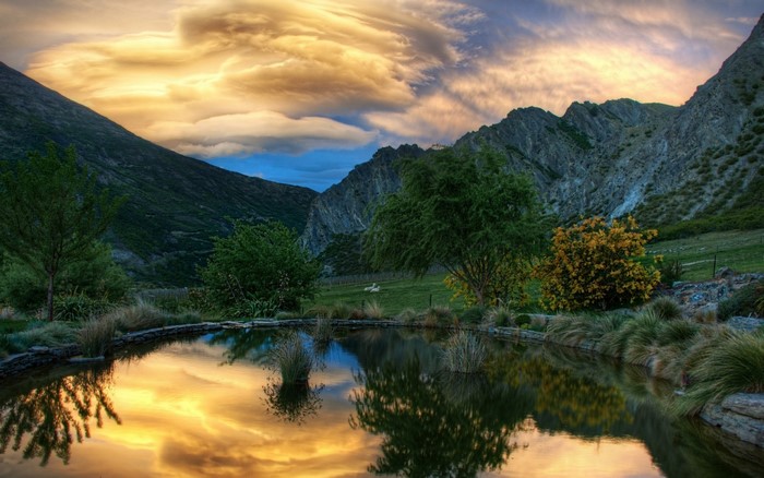 Mountain valley with a reflective pond at sunset
