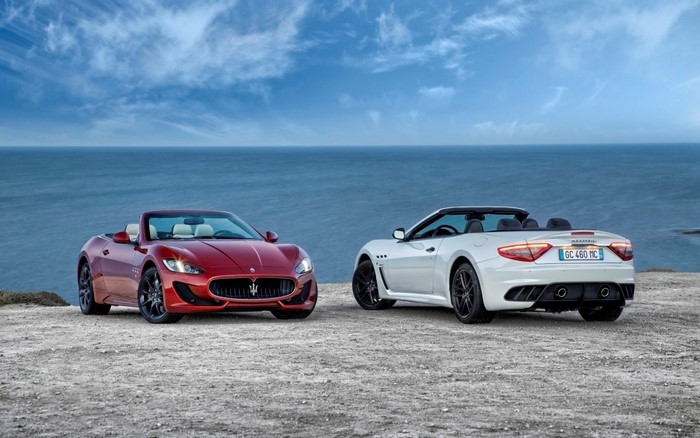 Two Maserati GranCabrio MC convertibles parked by the sea