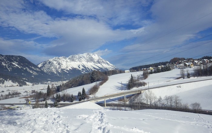 Snowy mountain landscape with a village and a bridge