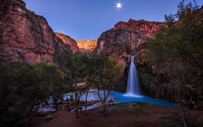 Waterfall in a canyon with a bright moon