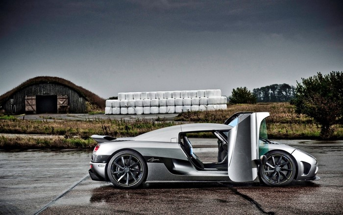 Koenigsegg Agera R parked in front of a barn and hay bales