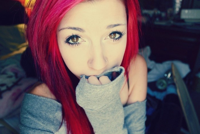 Young woman with bright red hair and nose piercing