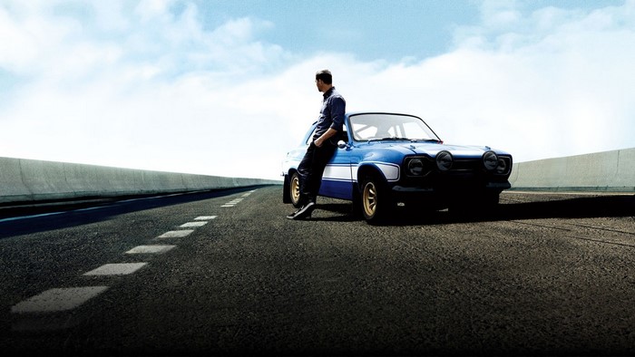 Man leaning on a blue Ford Escort Mk1 RS2000 on a road