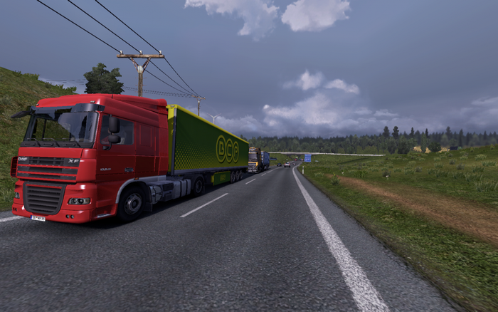 Red DAF truck with green trailer on highway