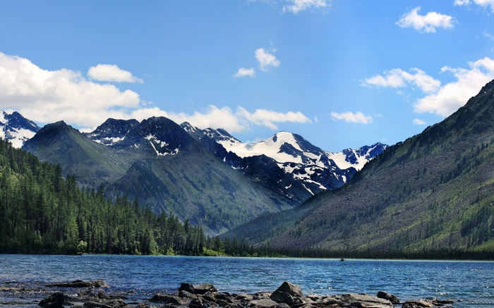Lake and snow-capped mountains under a blue sky