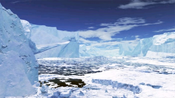 Icebergs and sea ice under a blue sky with clouds