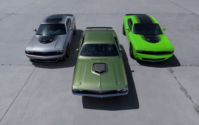 Three Dodge Challengers in different colors on concrete