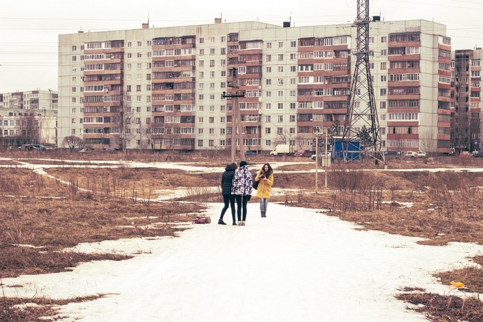 People walking on a snowy path in a Russian suburb