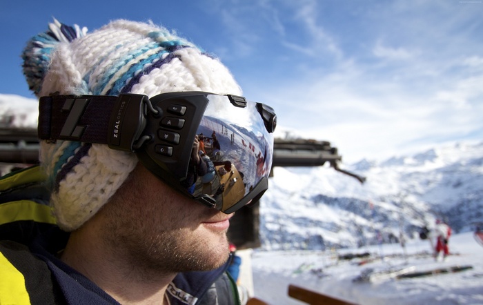 Man wearing Zeal Optics goggles in snowy mountains