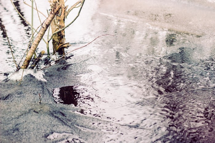 Frozen stream with branches and ice