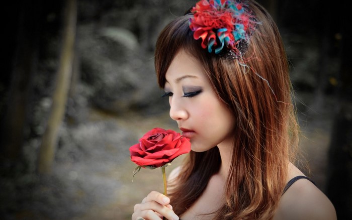 Woman smelling a red rose