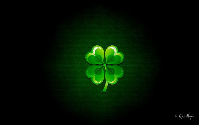 Green four-leaf clover on a dark textured background
