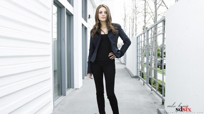 Mila Kunis in a black outfit and jacket