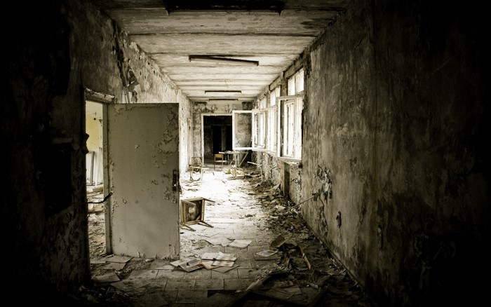 Abandoned hallway with peeling paint and debris
