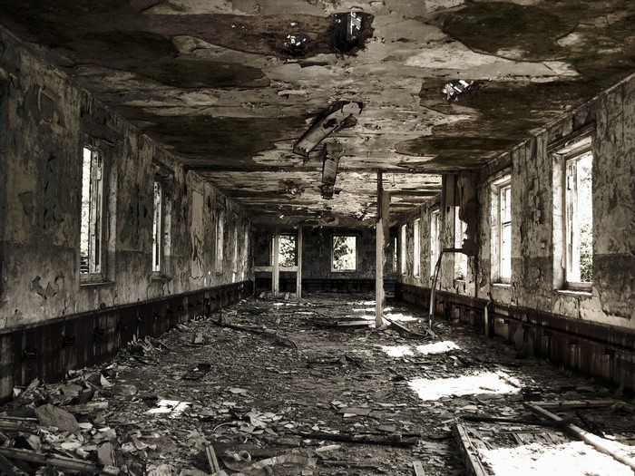 Abandoned building interior with debris and broken ceiling