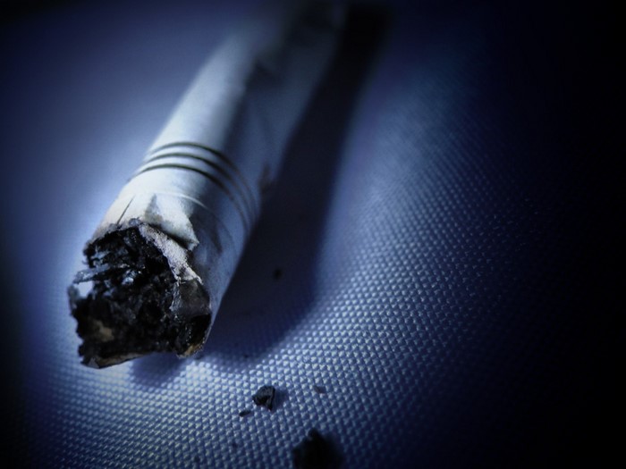 Close up of a burnt cigarette on a textured surface