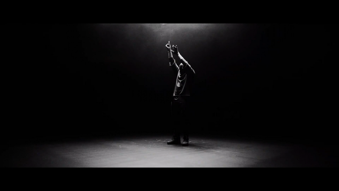 Man dancing in spotlight on dark stage